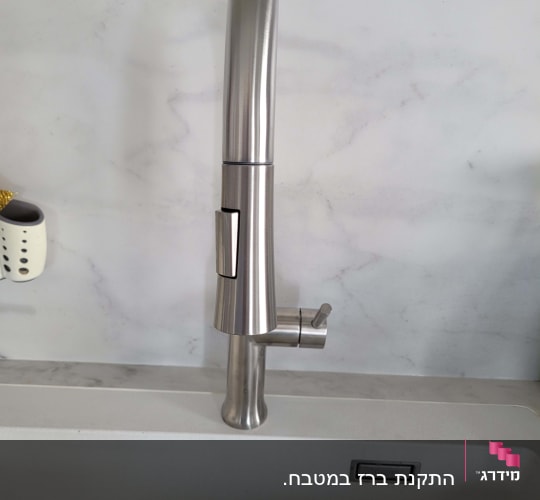 ברז נירוסטה מותקן בכיור מטבח לבן